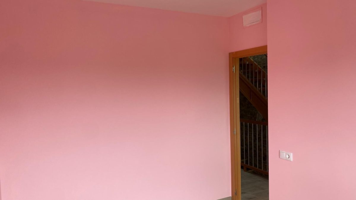 Dormitorio con paredes en rosa pastel y acabados delicados