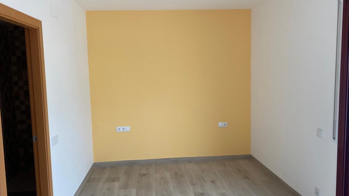 Habitación en tonos cálidos con pared amarilla