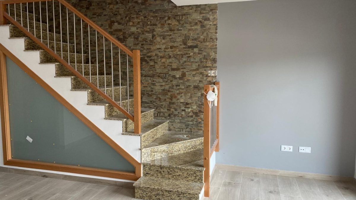 Escalera con pared de piedra y acabado en gris elegante